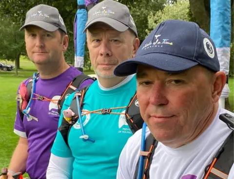 3 Dads Walking The thee dads look at the camera