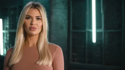 BBC Christine McGuinness, a blonde woman wearing a pink top in front of a green background
