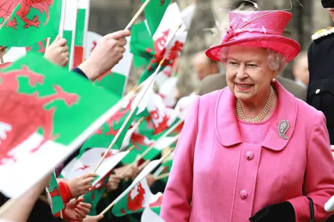 Getty Images Queen Elizabeth II was cheered by school children with flags as she arrived at Caernarfon Castle in 2010