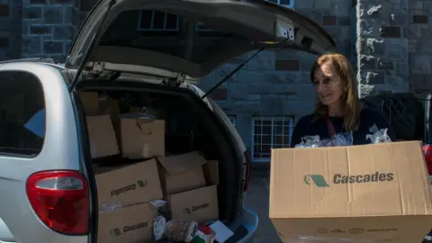Andreane Williams Rachel Lapierre unloads a car full of bread for distribution to refugee families